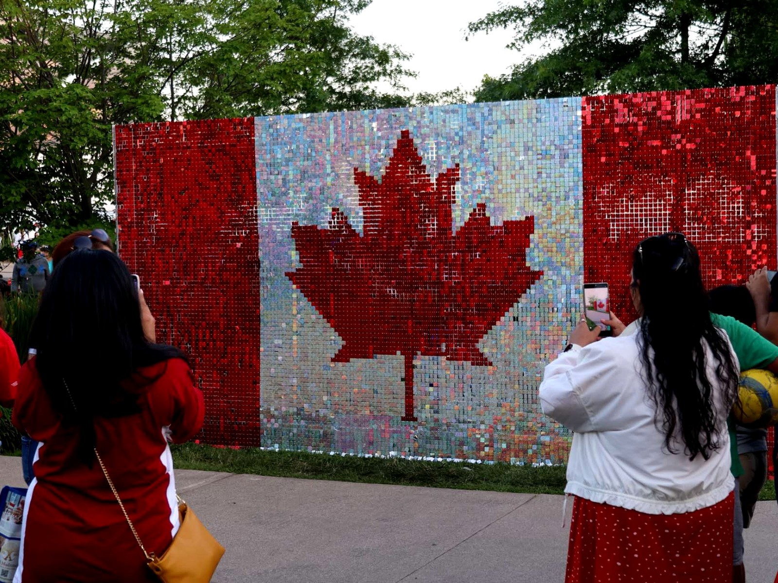 Crowd taking photos in front of the Canada flag shimmer wall