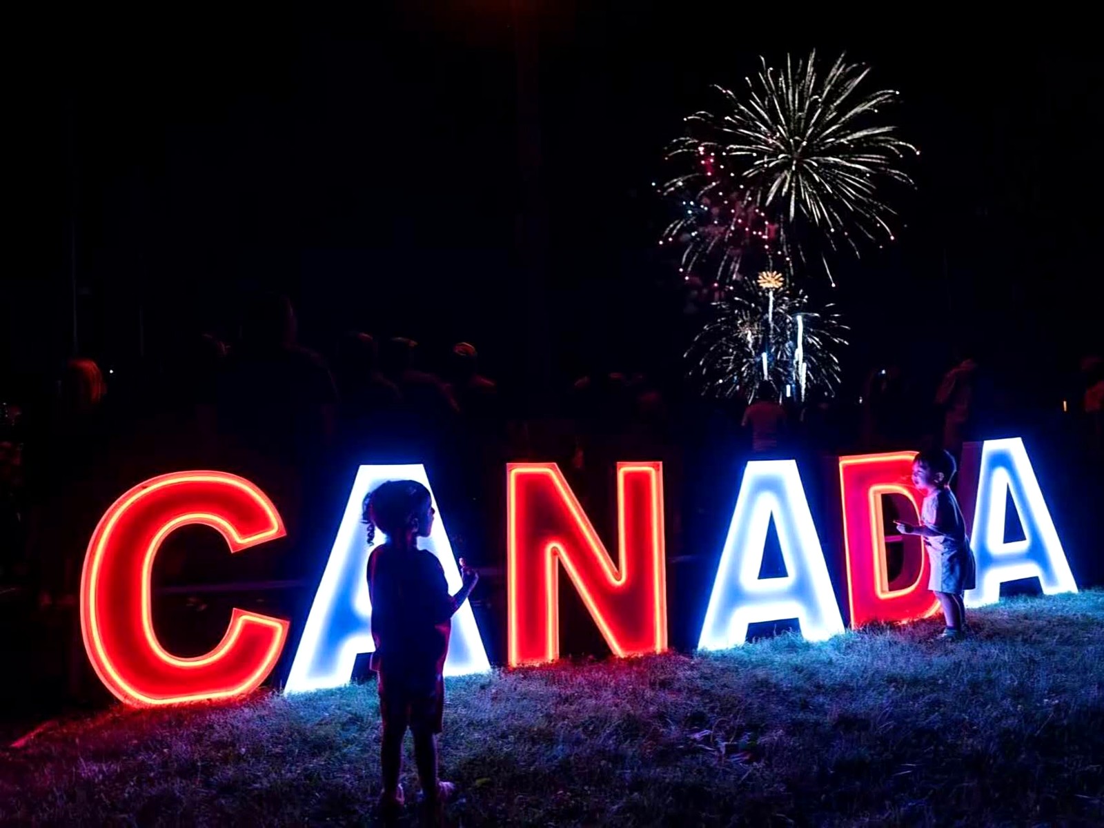 CANADA neon marquee letters with fireworks at night